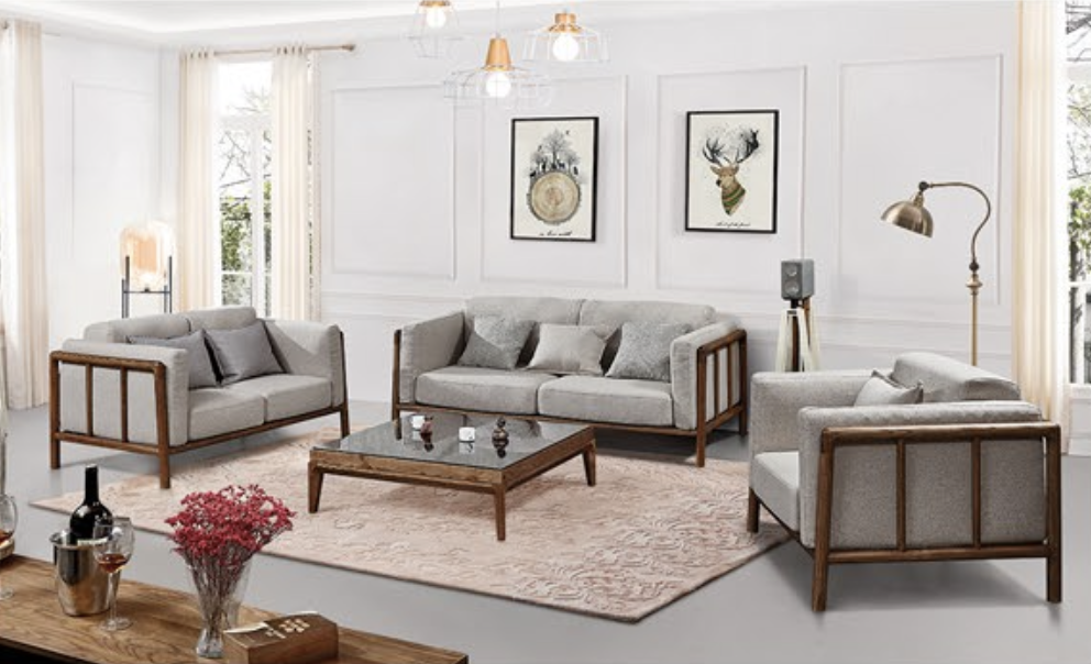 Living room with modern furniture including three gray sofas, a wooden coffee table, a pink area rug, and wall art featuring a deer and a tree.
