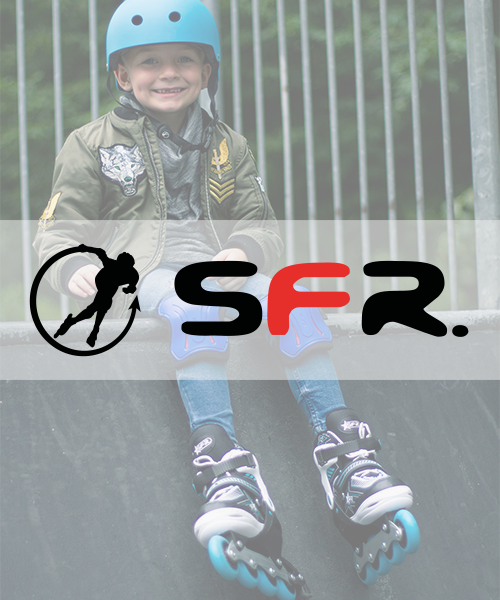 A young boy wearing an SFR Skates helmet and rollerblades, sitting on a ledge with a metal fence in the background.