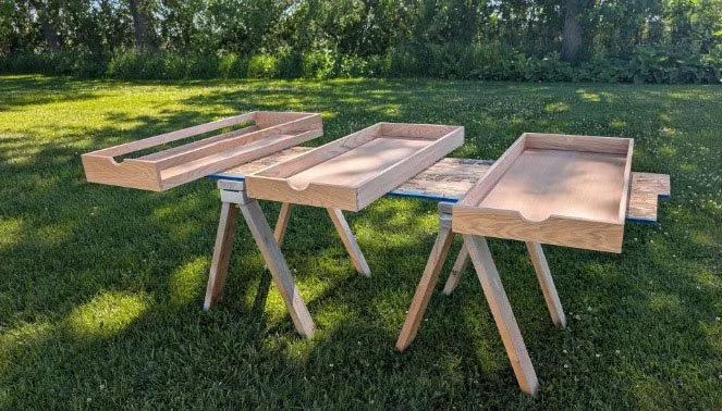 Red oak boards on sawhorses outdoors before milling