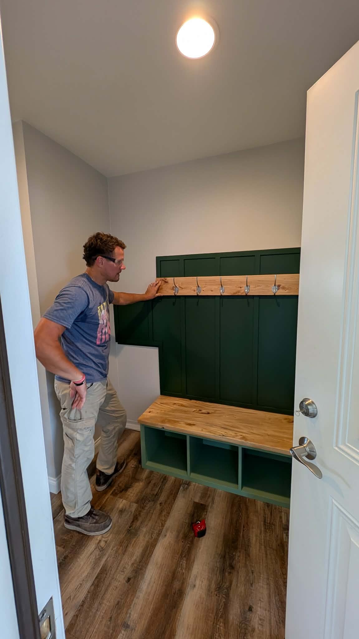 Installing dark green back panel in mudroom built-in