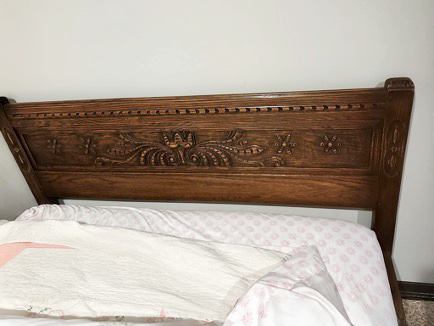 Antique wood headboard with carved floral details before being converted into a bench.