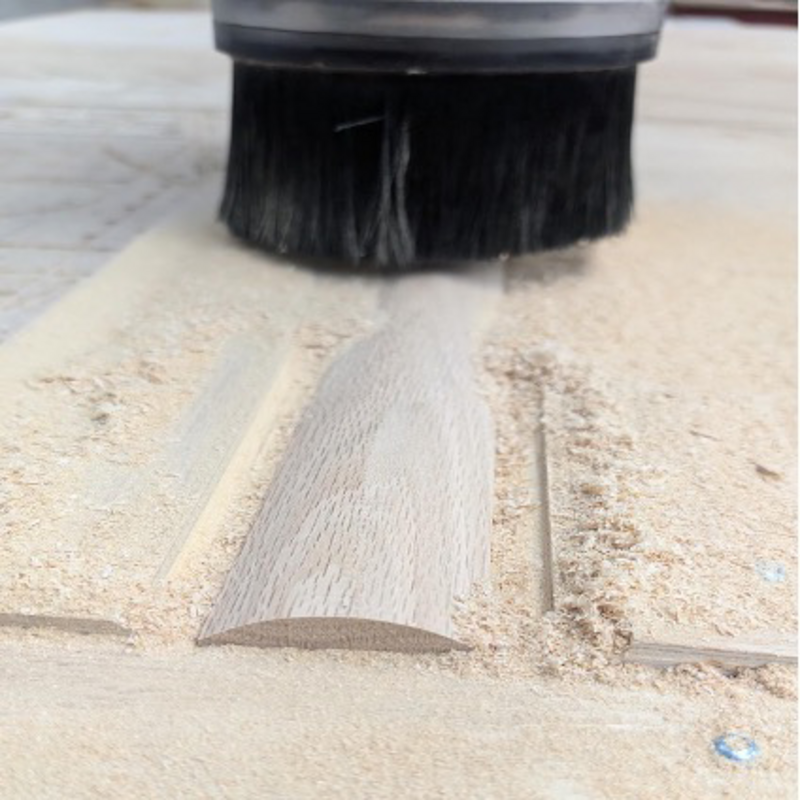 Router shaping the oak trim used on the custom bench apron.