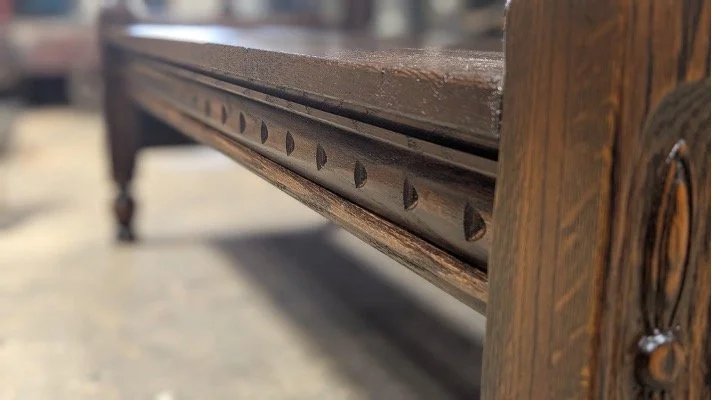 Close-up of the custom-routed decorative apron beneath the bench seat.