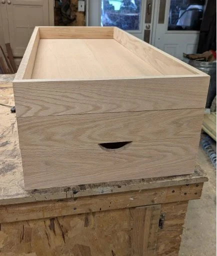 Assembled red oak drawer with cutaway handle detail