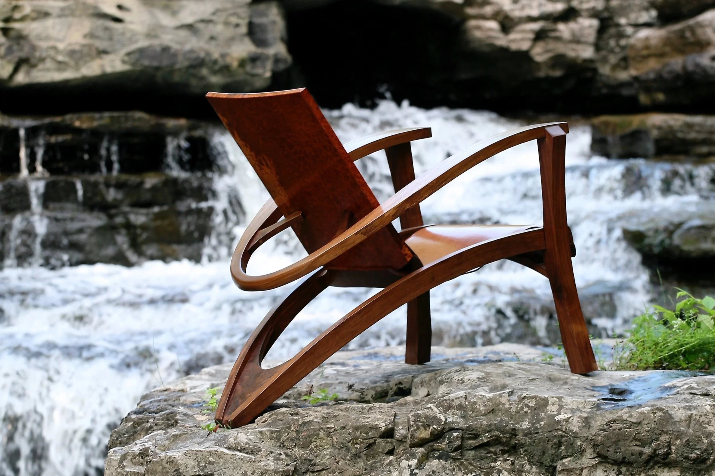 Chair on rock with waterfall in background