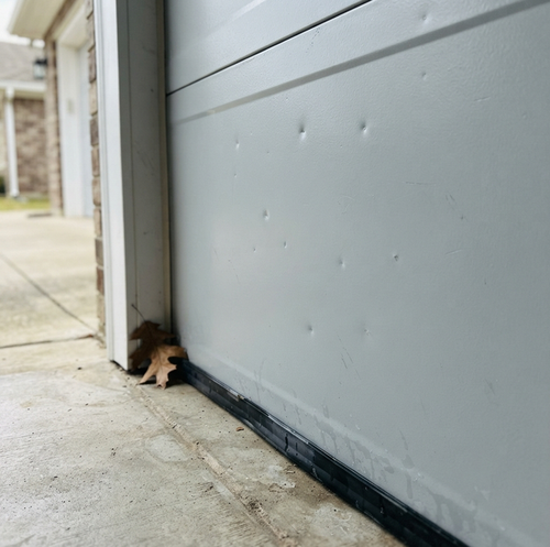 hail-damaged garage door with surface dimples