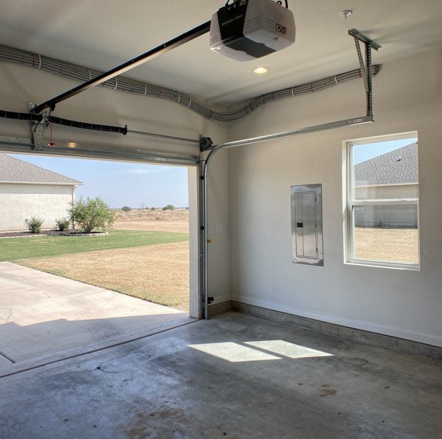 detached garage door opener across driveway with house in background