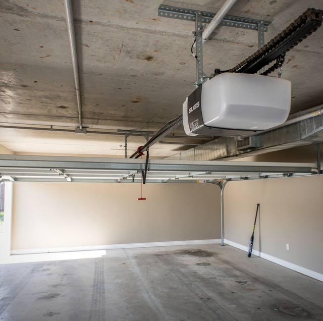 white garage door opener with two remotes on concrete floor