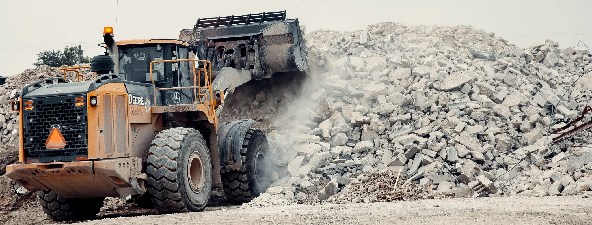 A large loader is moving recycled concrete at a recycling center.
