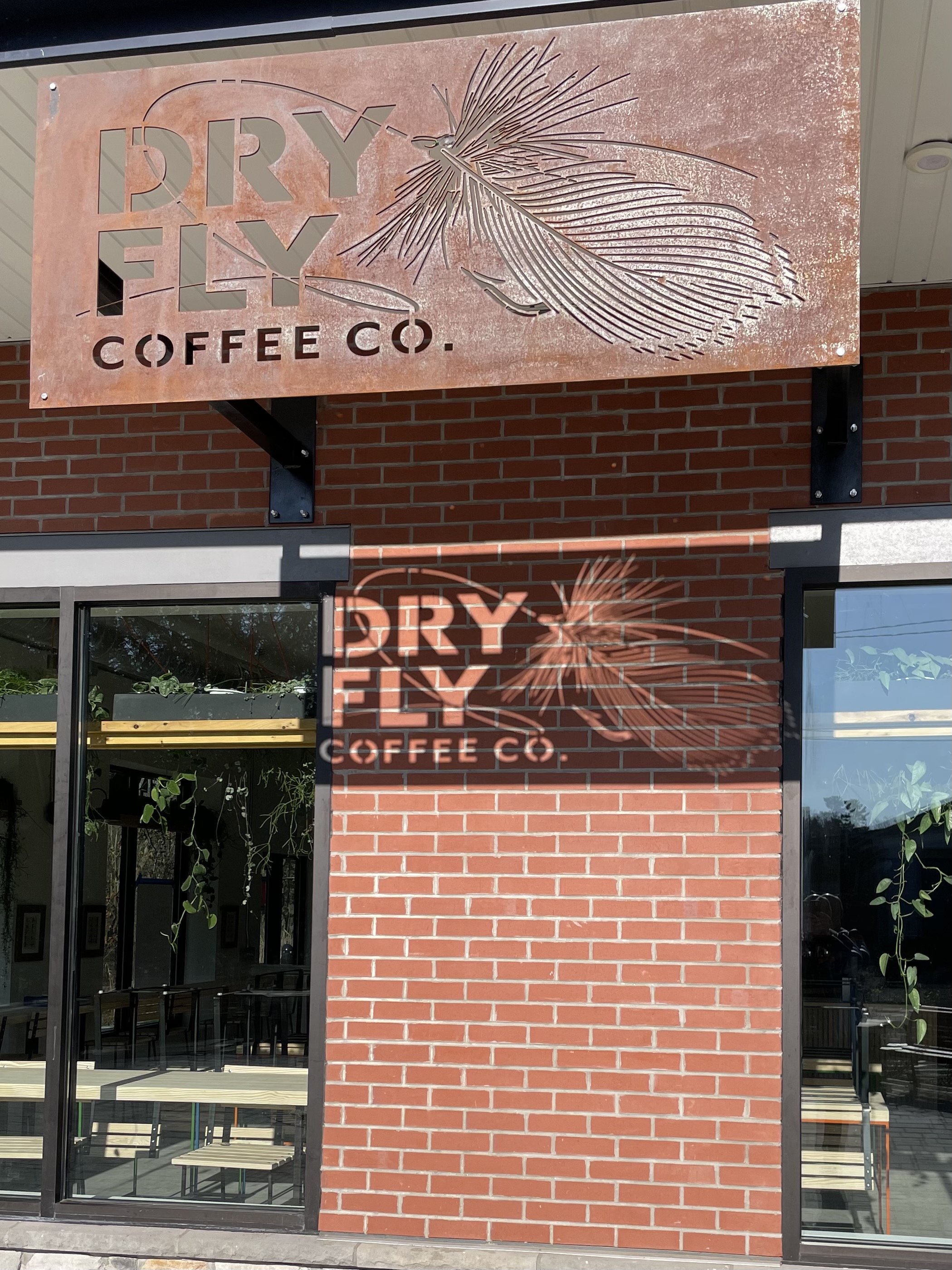 Sign for Dry Fly Coffee Co. with a line art logo of a dry fly lure.
