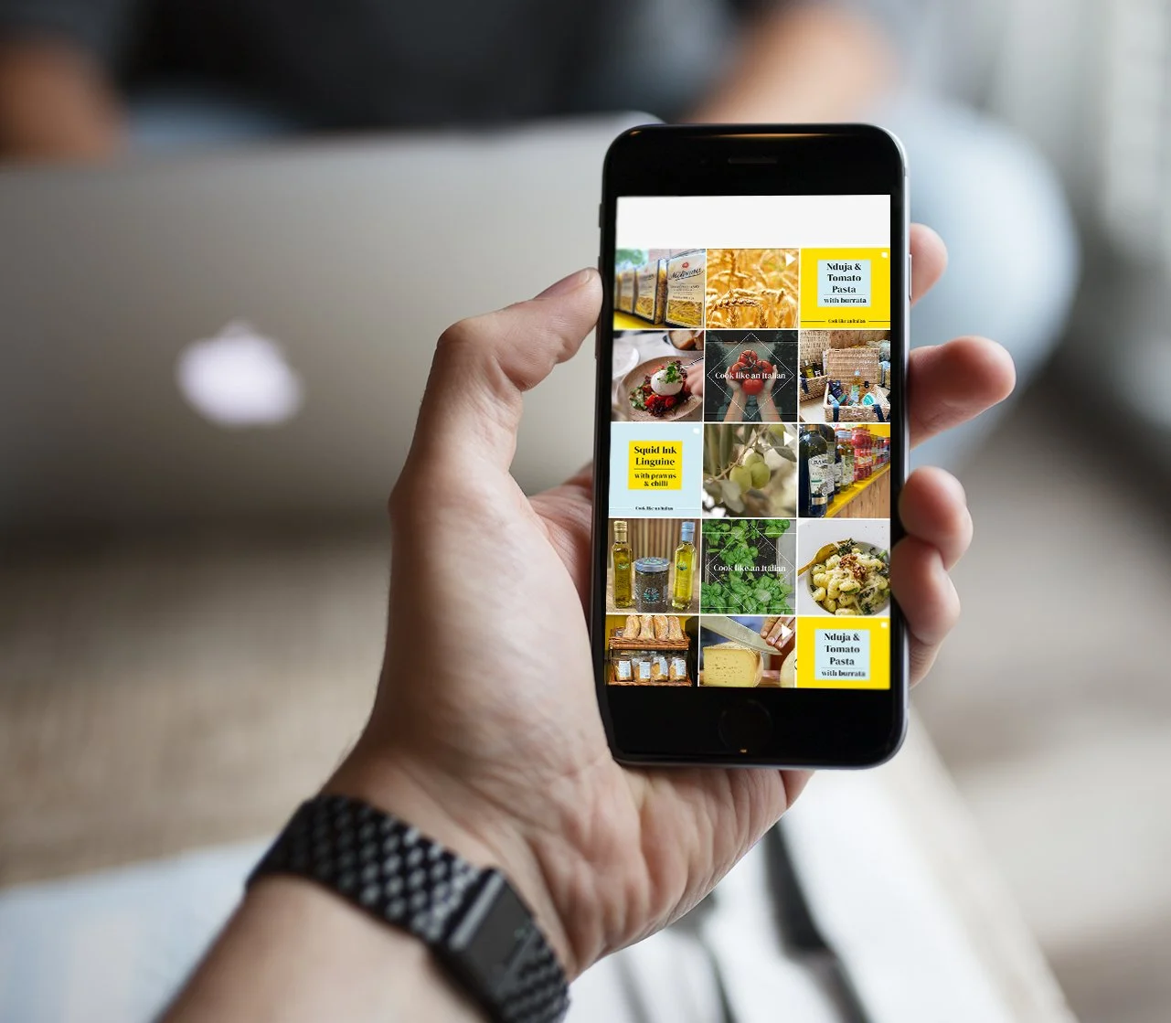 Hand holding smartphone displaying a collage of food and grocery images, including pasta, sauces, and ingredients.