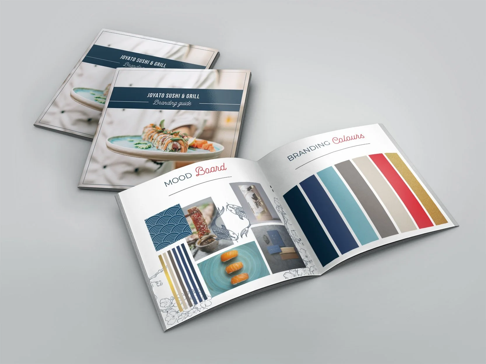 Open restaurant branding guide with mood board and colors pages, alongside two closed branding guide booklets featuring sushi images on a plain grey background.