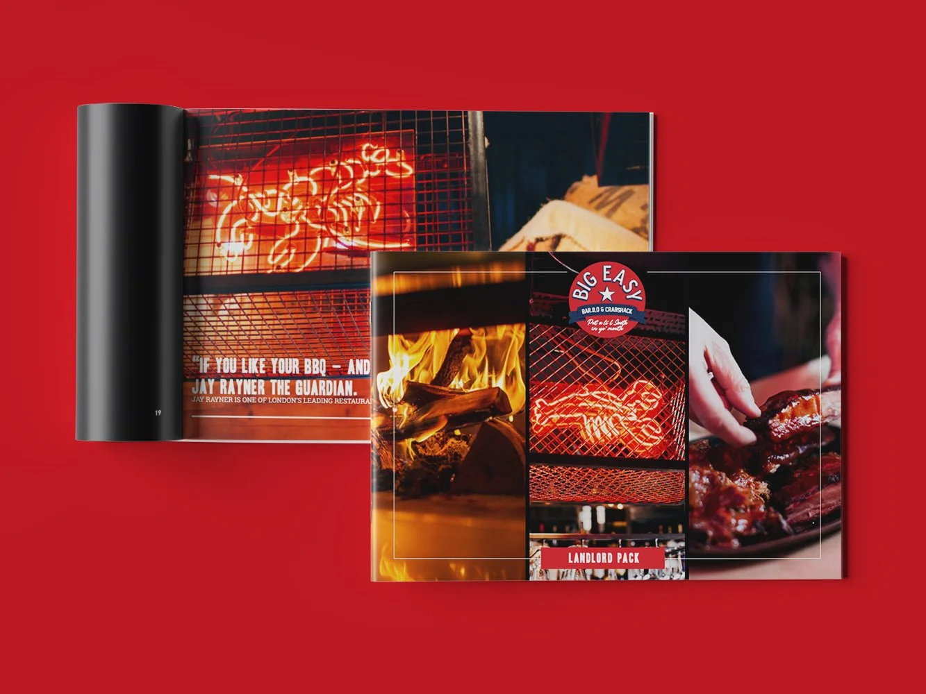 Open red hardcover magazine with images of barbecue grill, flames, and cooked meat, on a red background.