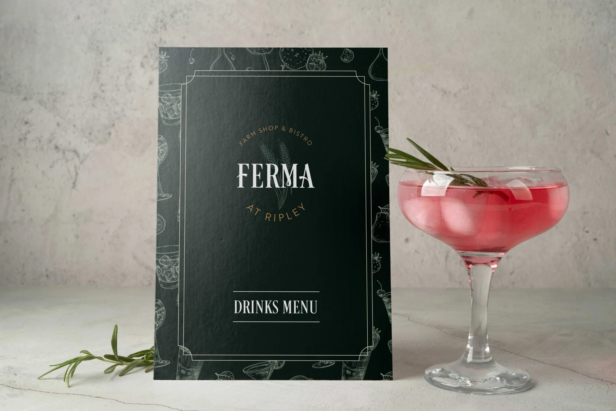 A menu and a pink cocktail with a sprig of rosemary on a white surface.
