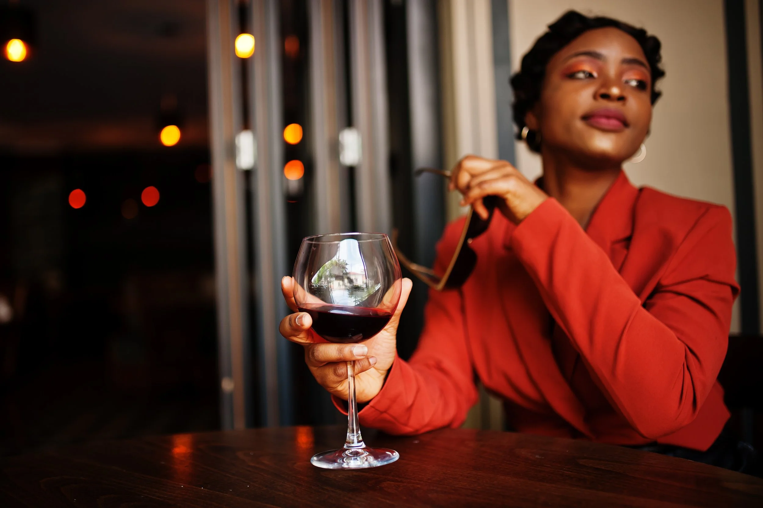 portrait-african-american-woman-retro-hairstyle-with-eyeglasses-wear-orange-jacket-posing-restaurant-with-glass-wine.jpg