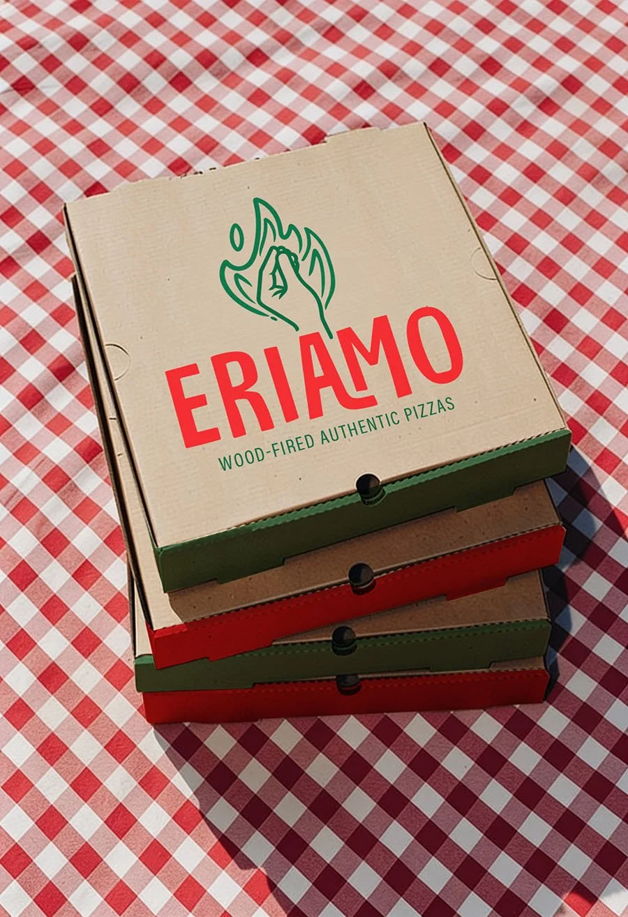 Restaurant Branding work for Eriamo featuring a stack of pizza boxes with Eriamo Wood-Fired Authentic Pizzas logo, featuring a hand in a flame, on red and white checkered tablecloth.