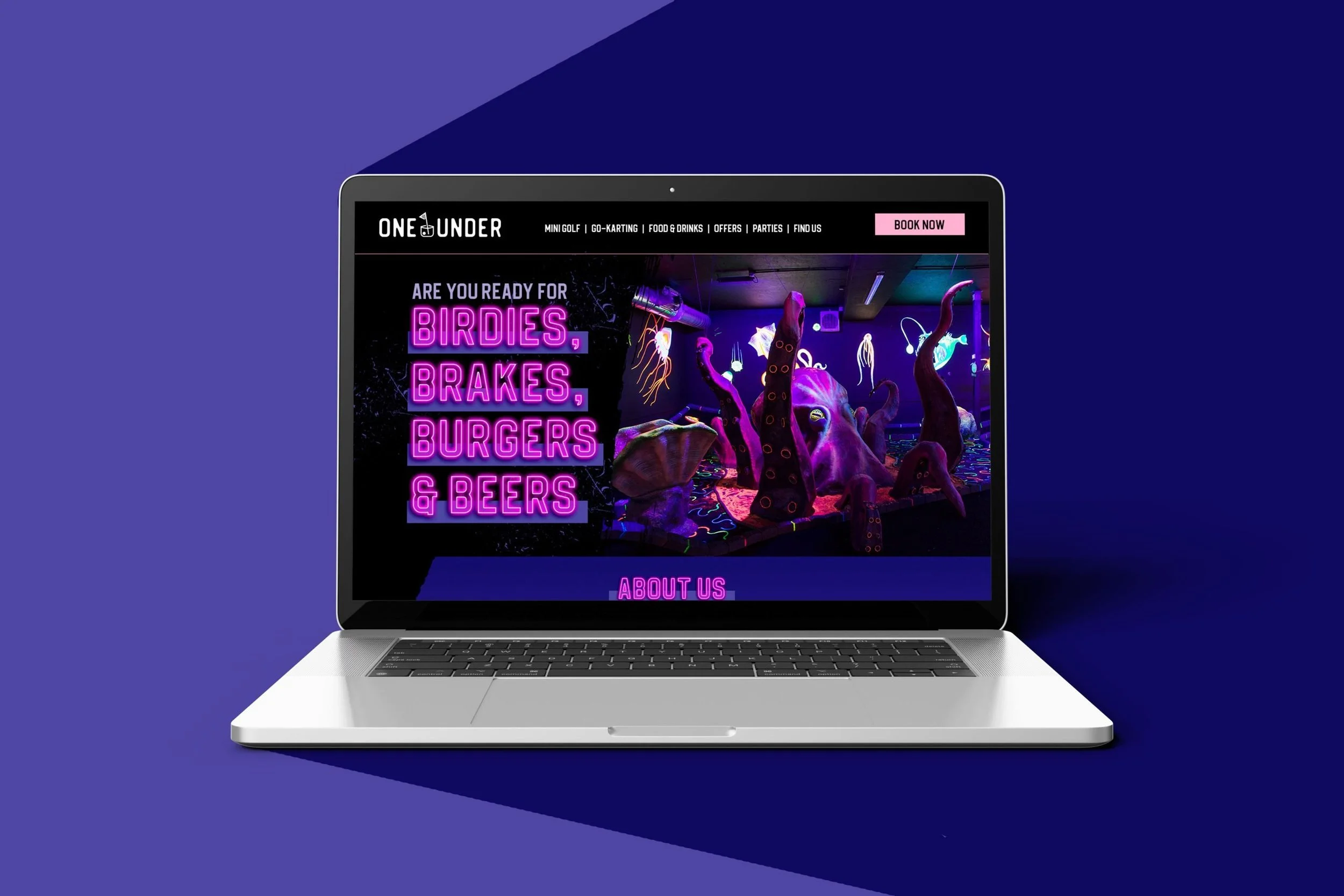 A laptop displaying a neon-themed website for an entertainment venue called 'One Under,' featuring attractions like mini golf, go-karting, food and drinks, parties, and offers, with neon signs and jellyfish decorations in the background.