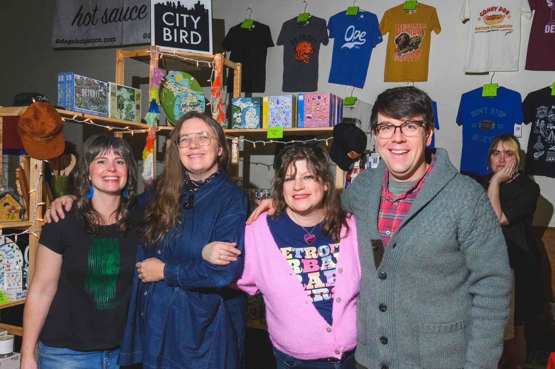 Bethany Nixon, Emily Linn, Carey Gustofson, and Andy Linn in the City Bird booth at the 2025 Detroit Urban Craft Fair. Bethany and Carey were the founders of the event. Emily and Andy are proud to carry on the tradition.