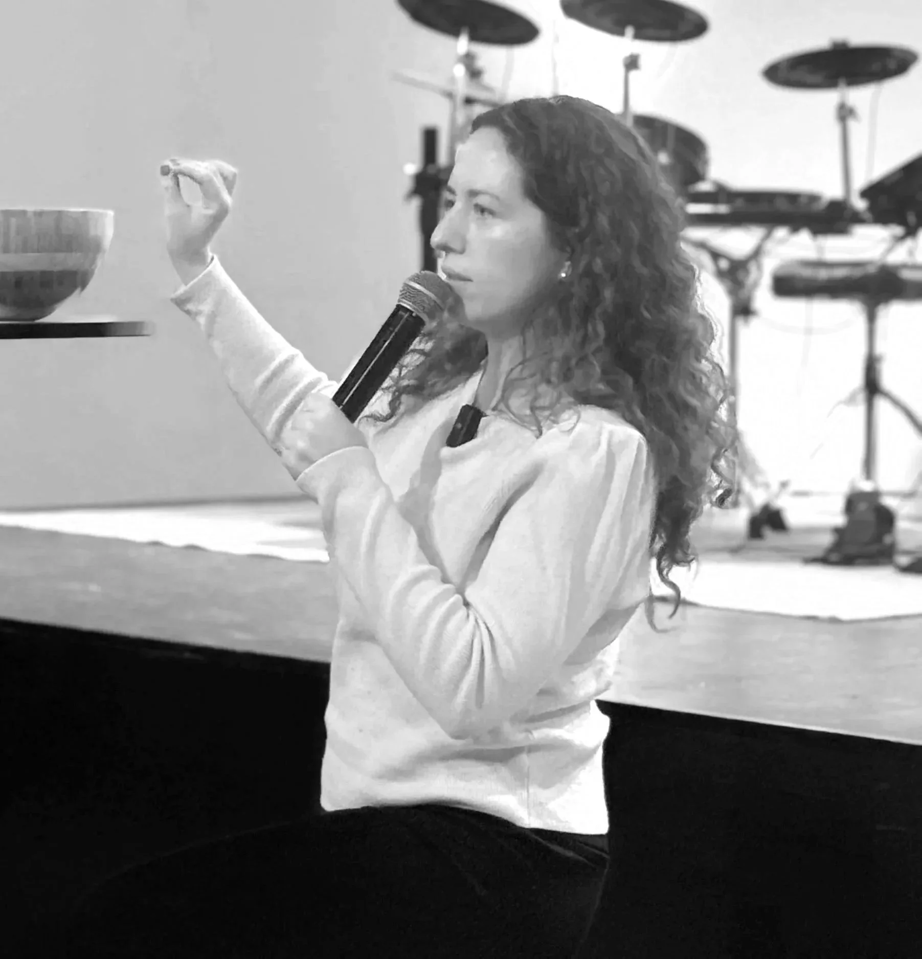 Joy Carignan speaking into a microphone with one hand raised.