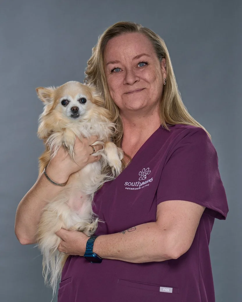 Cass headshot, woman in purple scrubs holding her dog