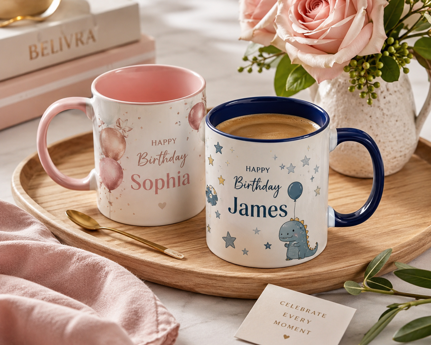 Elegant personalized ceramic celebration mugs displayed on a wooden tray with fresh flowers, a warm cup of coffee, and boutique styling. One feminine birthday mug and one playful boys' birthday mug, photographed in bright natural light.