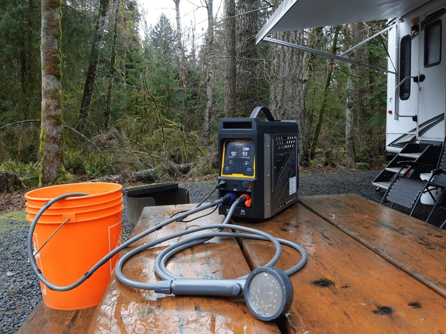 BougeRV propane water heater set up at a forest campsite with bucket and hose
