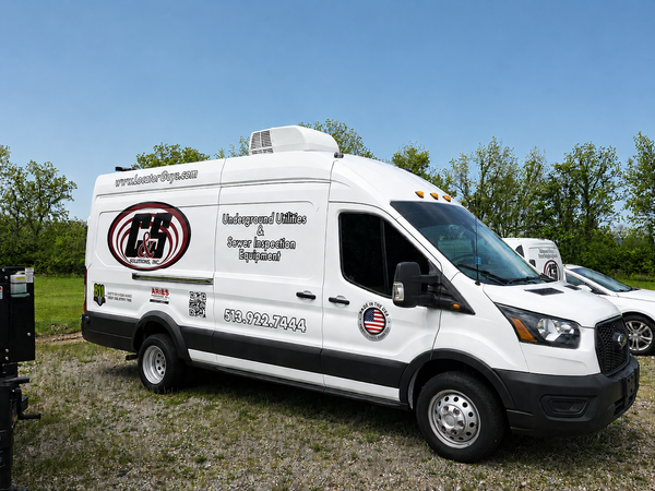 Sewer inspection demo van outfitted with a complete pipeline inspection system, parked outdoors.