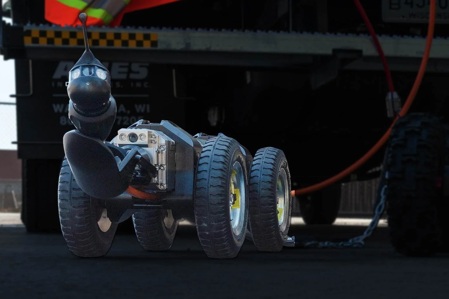 LETS 6.0 lateral inspection crawler positioned near an equipment truck with orange cable attached.