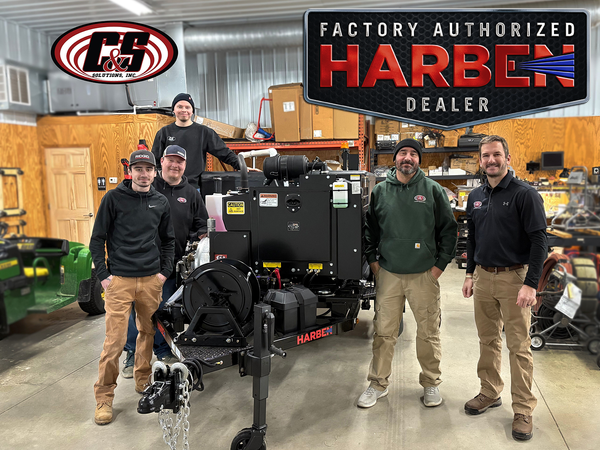 C&S Solutions team standing together in a warehouse with a Harben high-pressure water jetting unit.