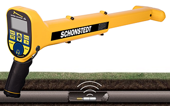 Schonstedt XT-512 locator shown above an underground sonde signal source for non-metallic pipe tracing.