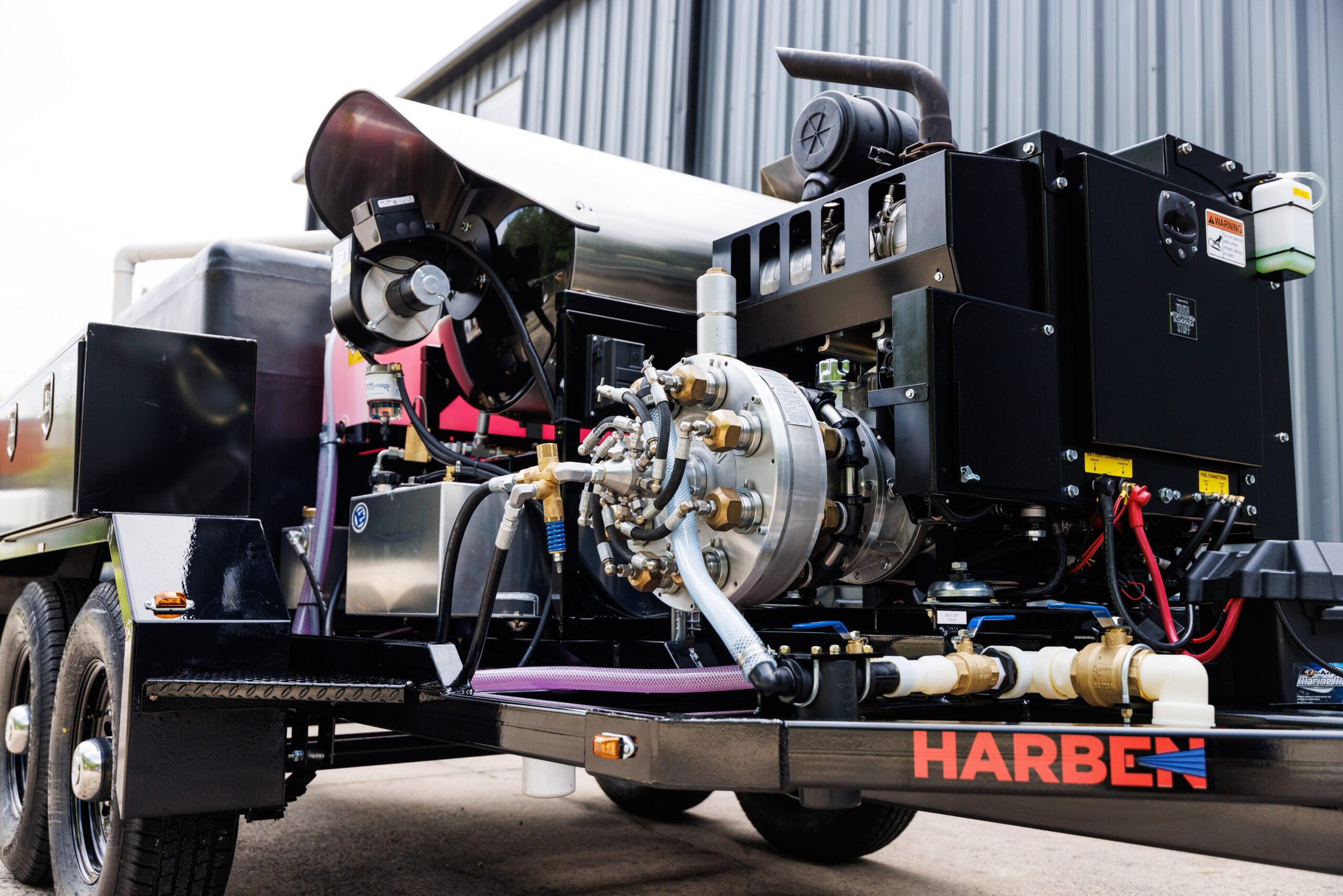 Harben trailer-mounted hydro jetting unit with engine, hose reel, and tank for sewer line cleaning.