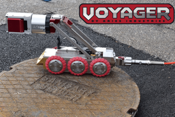 Aries Voyager HD Mainline Inspection System crawler positioned on a manhole cover.
