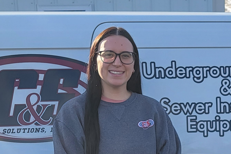 Tori, Locator Guys Office Assistant, standing in front of a company service van.