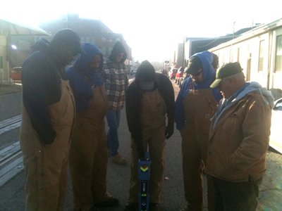 Crew wearing chest waders gathered outdoors for cold-weather field training.