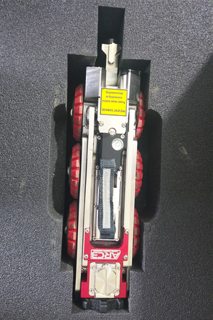 Close-up top-down view of a mainline inspection crawler secured in its van storage mount.