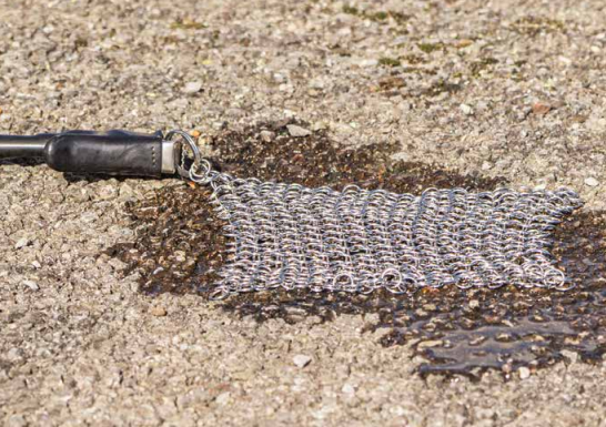 Close-up of the Radiodetection Earth Mat connected to a transmitter on a gravel surface.