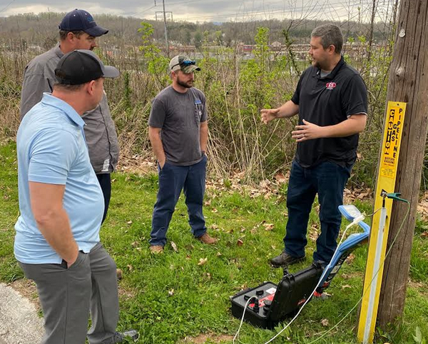 Instructor demonstrating locating equipment to a group during a Locator Guys outdoor field training session.