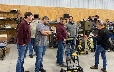 Locator Guys team providing on-site training to technicians on utility locating equipment in a shop setting.
