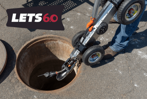 LETS 6.0 lateral inspection tractor being lowered into a manhole for mainline and lateral pipe inspection.