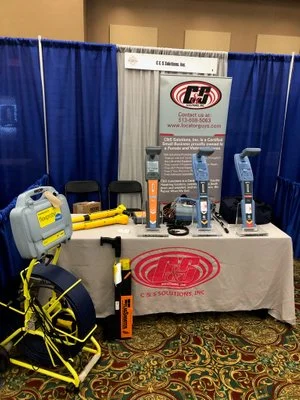 C&S Solutions trade show booth display with a blue curtain backdrop.