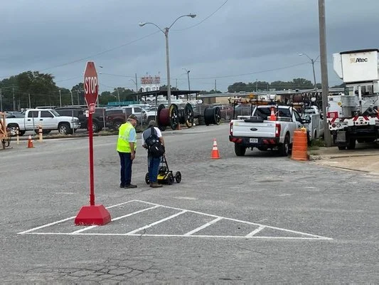 Technician using a ground penetrating radar unit alongside a locator demonstration in a Memphis, Tennessee parking lot.