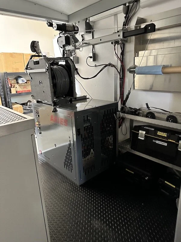 Pipeline inspection camera reel and equipment rack mounted inside an Aries inspection trailer.