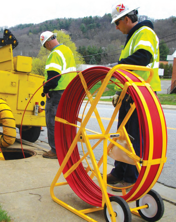 Field crew members using a large-frame Jameson Duct Hunter traceable rodder reel to locate underground pipe.