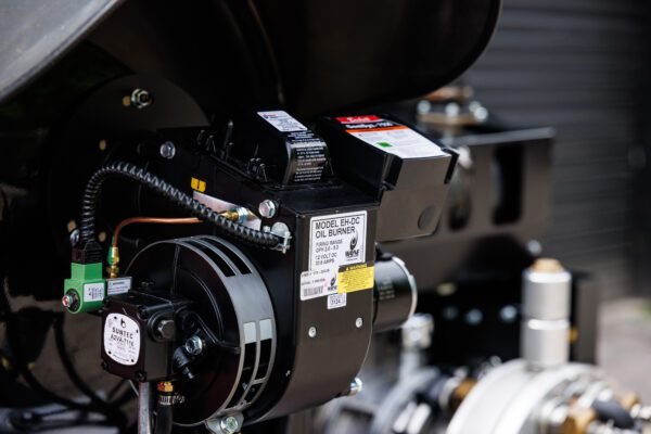Close-up of an oil burner heating component mounted on a hydro jetting unit.