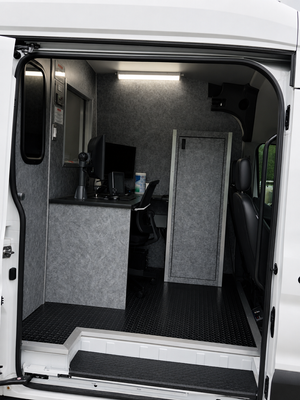 View into the side door of the sewer inspection van showing the equipment cabin layout.