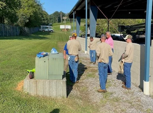 Technicians demonstrating utility locating equipment near a pedestal for the City of Loudon, Tennessee with Hi-Line Utility Supply.