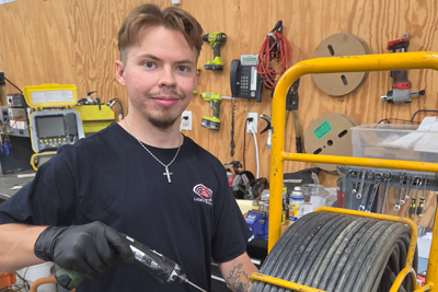 Evan Piersall, Locator Guys Factory Certified Repair Technician, working on equipment in the repair shop.