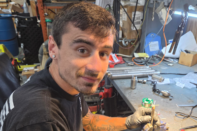 Tyler, Locator Guys Office Manager and Factory Certified Repair Technician, working on equipment.