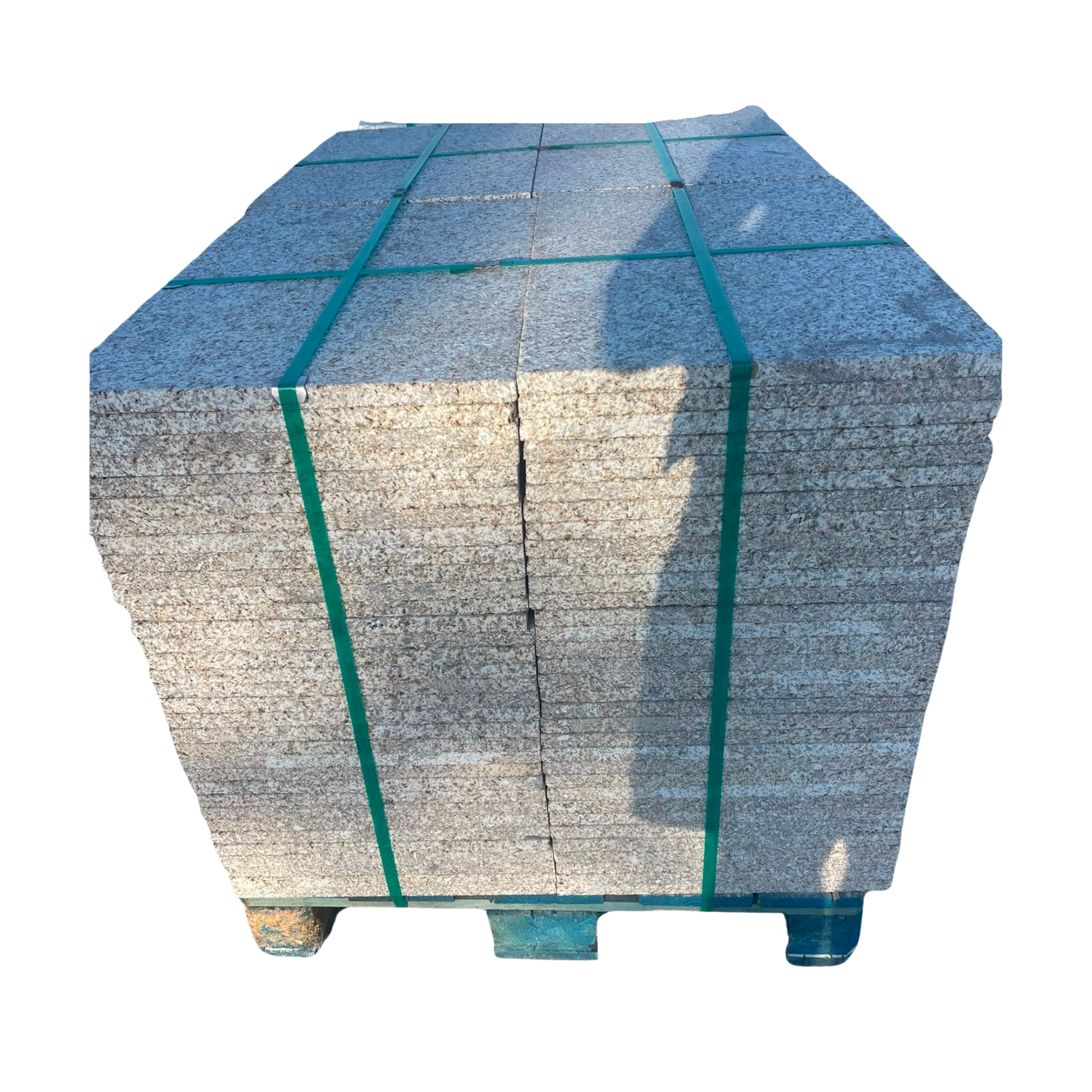Bloc de pierre de granit gris avec des bandes de plastique vertes pour le transport.