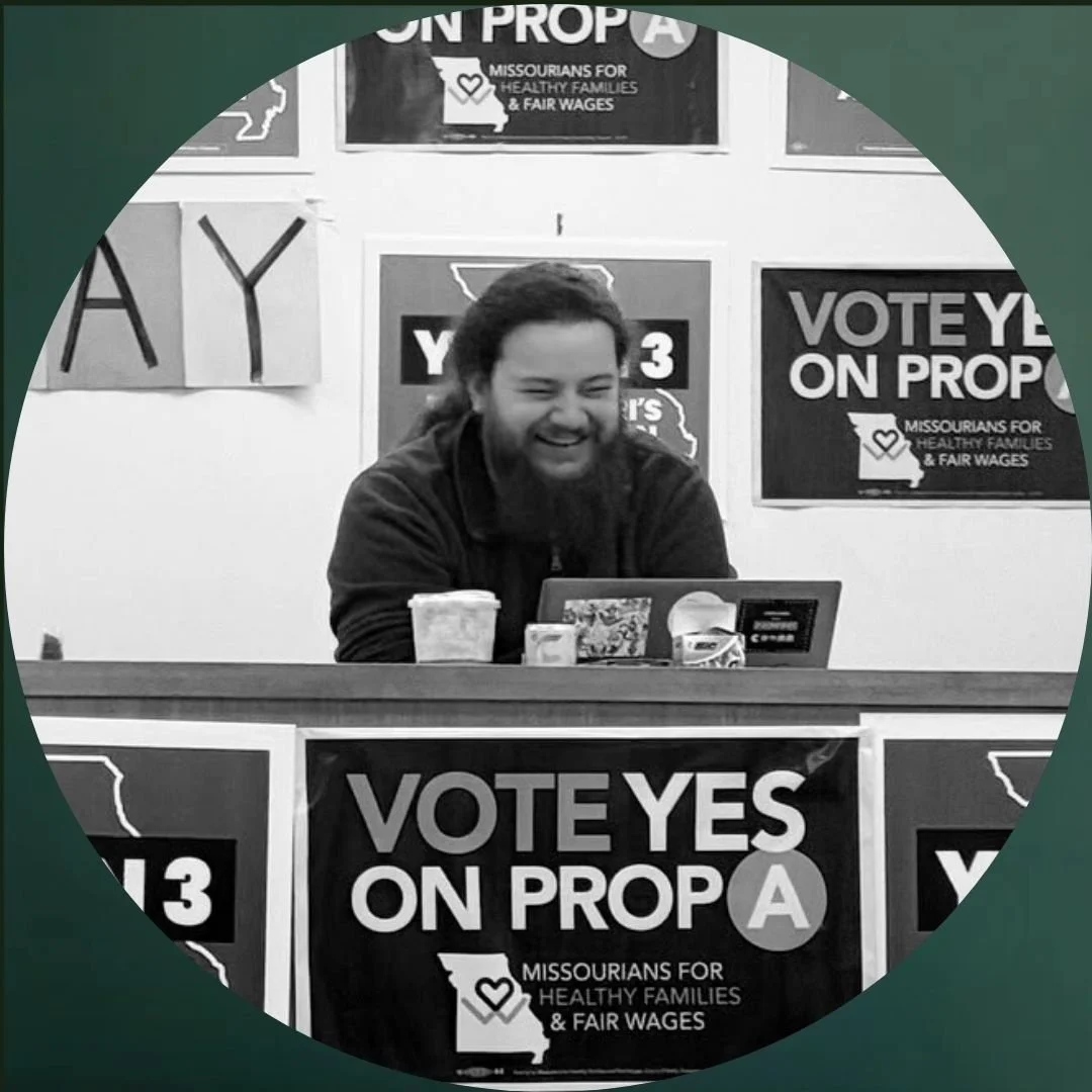 smiling man with curly hair sitting at a table for a voter panel
